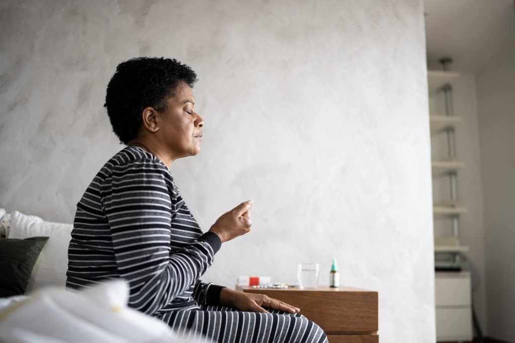 woman sitting on her bed while dealing with a benzodiazepine addiction